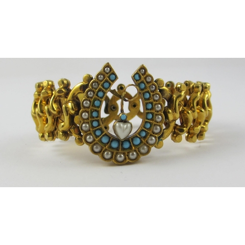 129 - A expandable yellow metal bracelet  with a central horseshoe motif set with faux seed pearls and tur... 