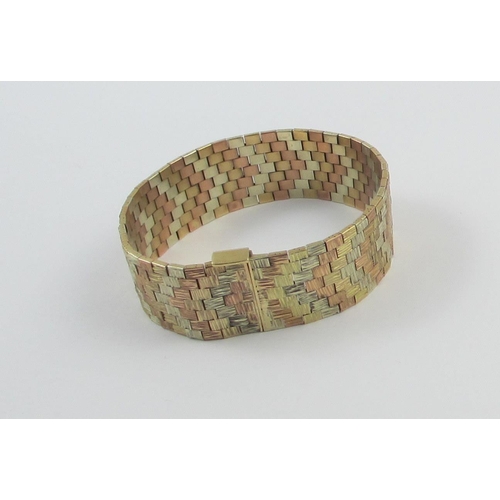 33 - A three colour gold bracelet. with bark textured finish  in chevron pattern. Approx weight 46.5gms