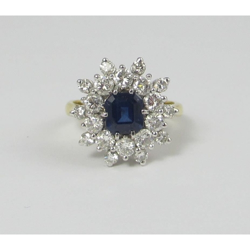 66 - A sapphire and diamond cluster ring  The central emerald cut sapphire of approx 6.1mm surrounded by ... 