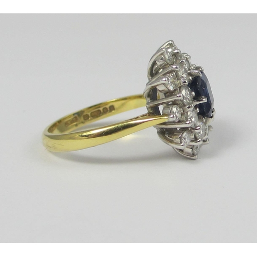 66 - A sapphire and diamond cluster ring  The central emerald cut sapphire of approx 6.1mm surrounded by ... 