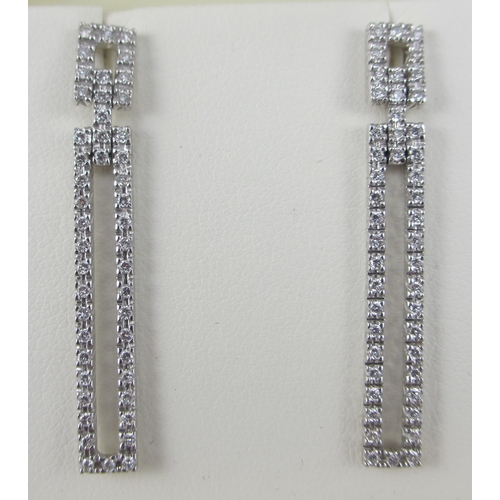 83 - A pair of long diamond set earrings in 18ct white gold. 47 pave set brilliant cut diamonds in each e... 