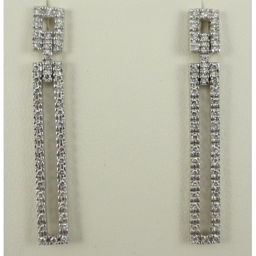 83 - A pair of long diamond set earrings in 18ct white gold. 47 pave set brilliant cut diamonds in each e... 