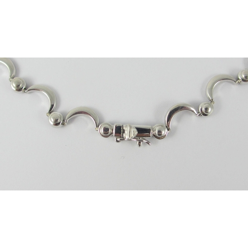 85 - An 18ct white gold diamond set crescent moon necklace. Necklace made up of thirty one crescent moon ... 