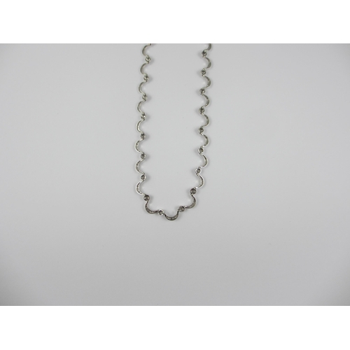 85 - An 18ct white gold diamond set crescent moon necklace. Necklace made up of thirty one crescent moon ... 