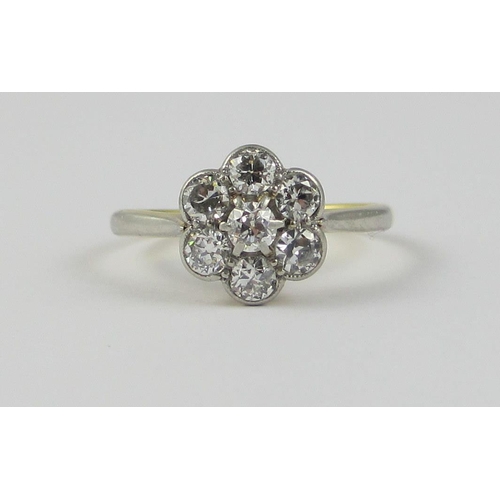 87 - A platinum and 18ct yellow gold diamond flower ring  approx diamond weight 0.70cts  the central diam... 