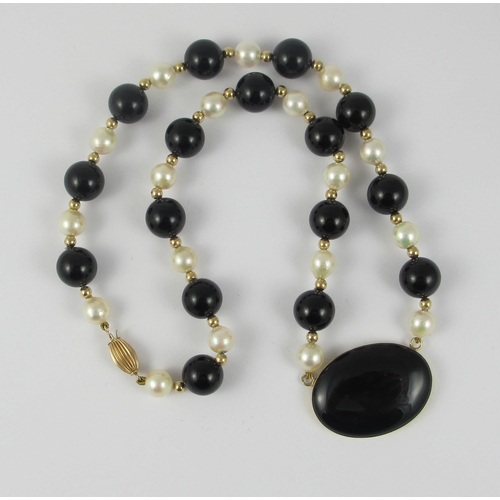 90 - A designer made yellow metal onyx and pearl necklace.