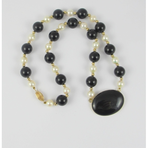 90 - A designer made yellow metal onyx and pearl necklace.