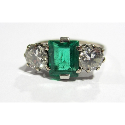 66 - An early 20 th century 18 ct white gold emerald and diamond three stone ring