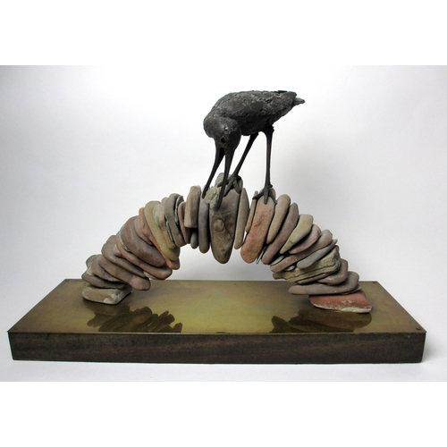 729 - A bronze model of a bird standing on a pebble built arched bridge