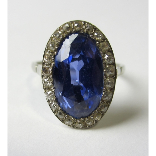 64 - A white metal Ceylon sapphire and diamond cluster ring