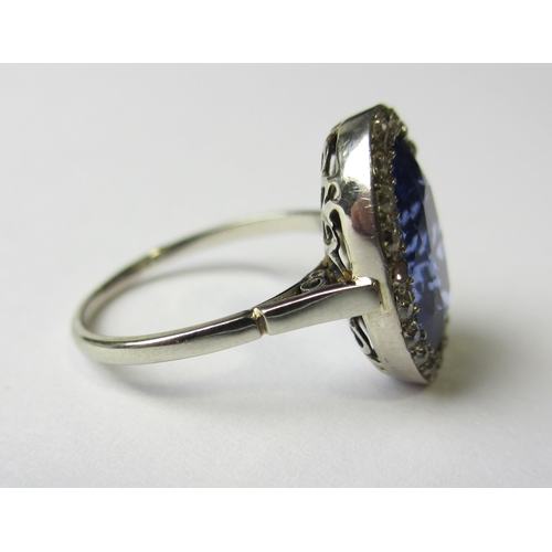 64 - A white metal Ceylon sapphire and diamond cluster ring