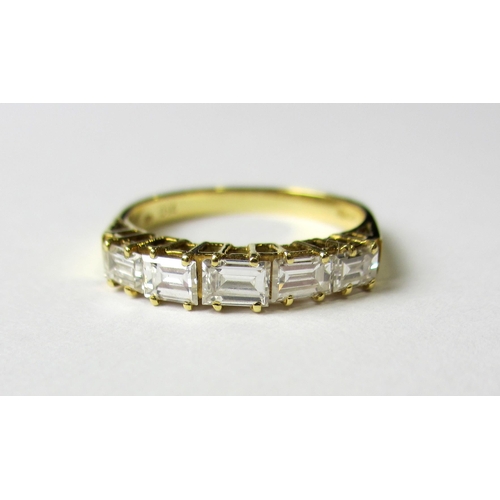 65 - An eighteen carat gold five stone baguette diamond half hoop ring