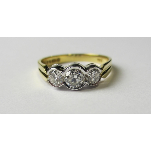 67 - An eighteen carat bi colour gold diamond three stone ring