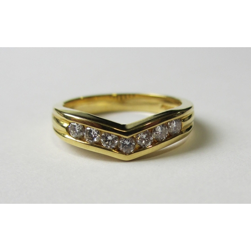 70 - An eighteen carat gold channel set diamond wishbone ring