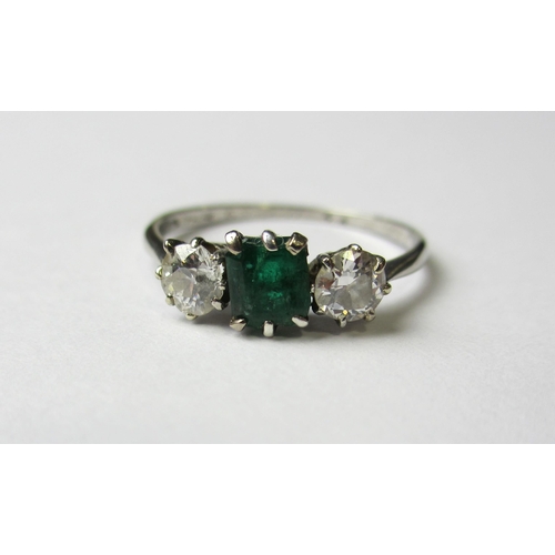 82 - A 1930's 18 ct white gold emerald and diamond three stone ring