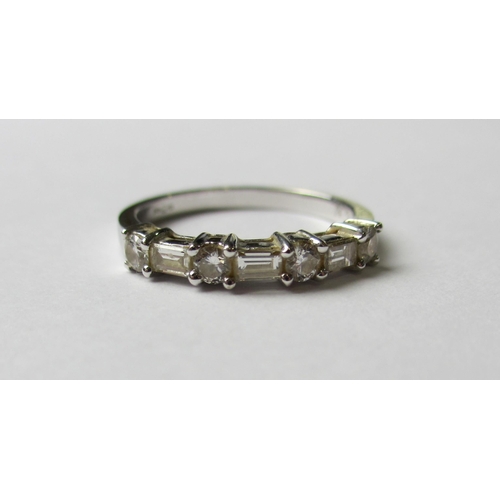 86 - Am eighteen carat white gold baguette and brilliant cut diamond half hoop ring