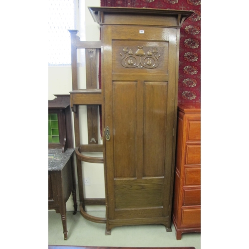 869 - An Art Nouveau oak hall wardrobe with a recess stick stand and decorated with carved stylised flower... 