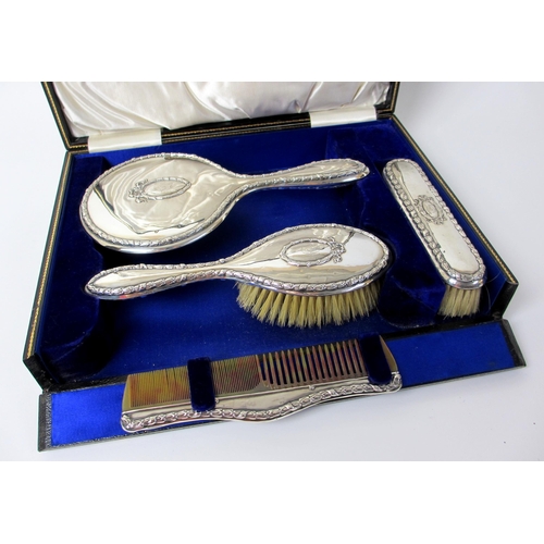 165 - A cased four piece silver dressing table set