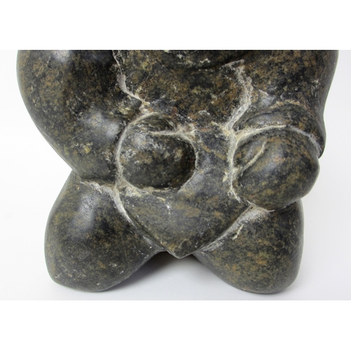 231 - An Inuit steatite / soapstone carving of a kneeling figure