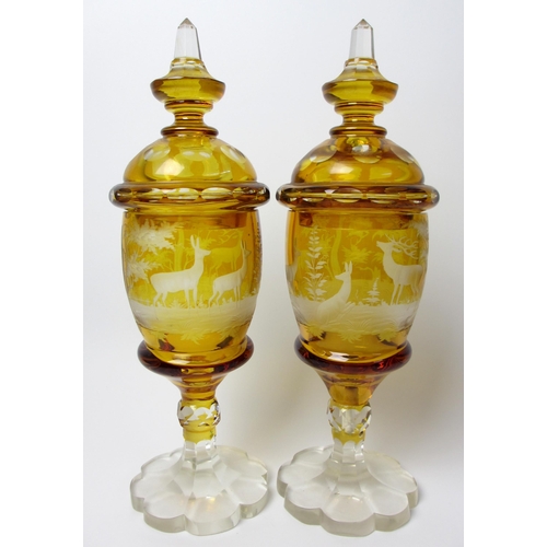 483 - A pair of Bohemian amber and engraved glass covered vases