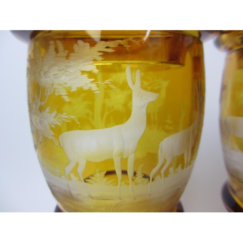 483 - A pair of Bohemian amber and engraved glass covered vases