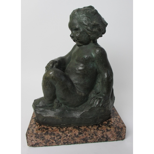 547 - A cast and painted sculpture of a young child seated on a rock