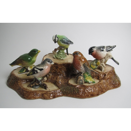 532 - A Beswick group of birds perched on a tree stump base