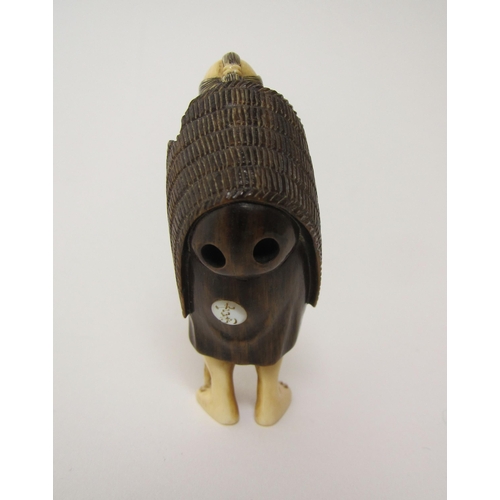 658 - A Japanese ivory and hardwood netsuke of a traveller