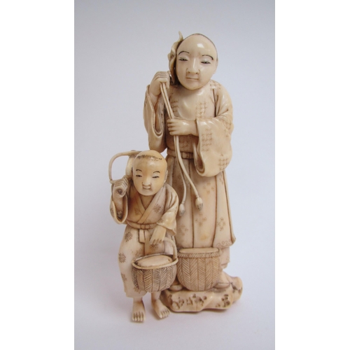 673 - A Japanese ivory okimono carved with a father and son