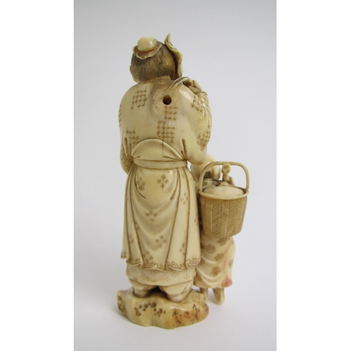 673 - A Japanese ivory okimono carved with a father and son