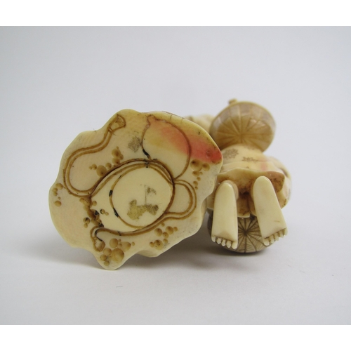 673 - A Japanese ivory okimono carved with a father and son