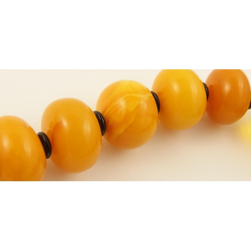 107 - Item 12. A mixed amber coloured bead necklace