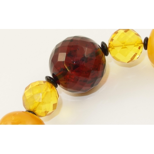 107 - Item 12. A mixed amber coloured bead necklace