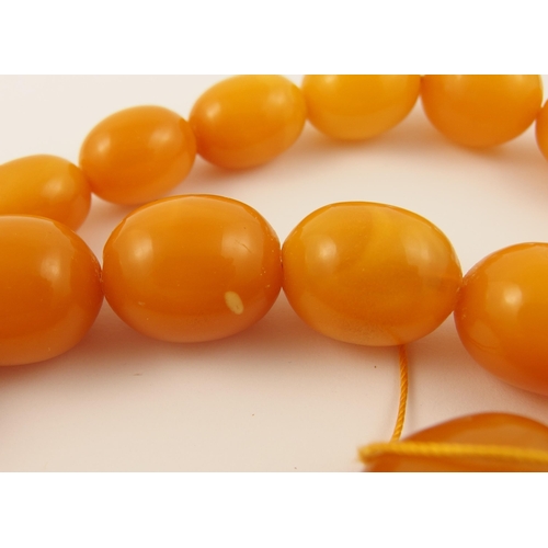 71 - A string of yellow amber coloured beads