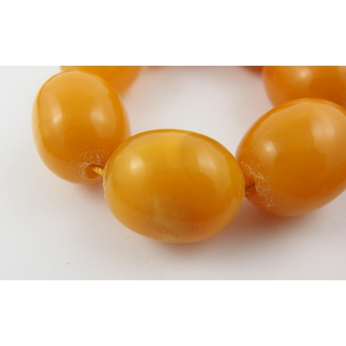 71 - A string of yellow amber coloured beads