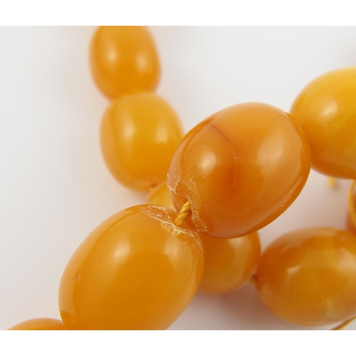 71 - A string of yellow amber coloured beads