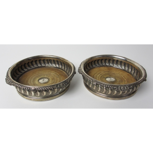 152 - A pair of late George III silver wine coasters