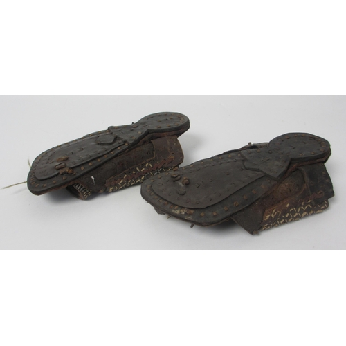 657 - A pair of leather and straw woven moccasins