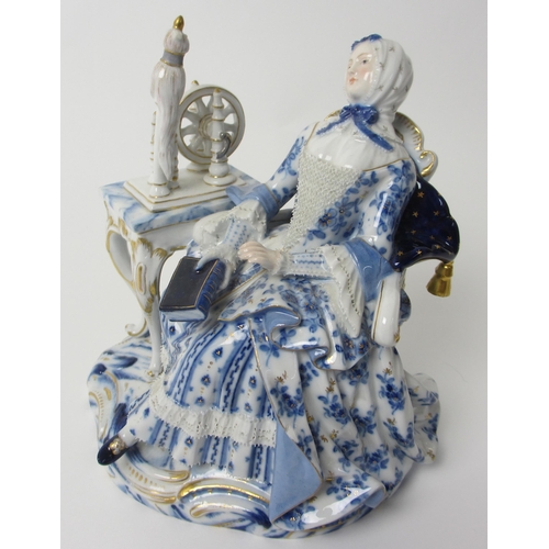 666 - A Meissen figure of a lady sat at her spinning wheel