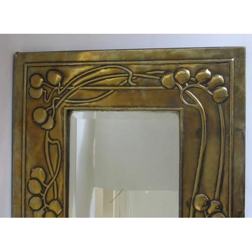 771 - A Glasgow style embossed brass tall rectangular wall mirror