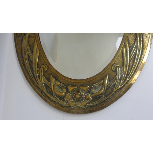 772 - A Glasgow style embossed brass oval wall mirror