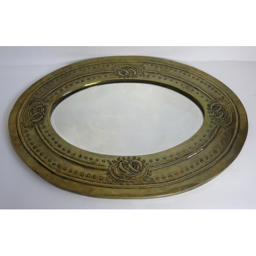 773 - A Glasgow style embossed brass oval wall mirror