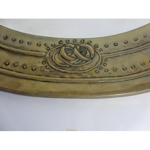 773 - A Glasgow style embossed brass oval wall mirror