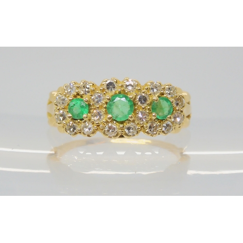 An emerald & diamond flower cluster ring, set with three emeralds, the largest approx 3.6mm, surrounded with estimated approx 0.30cts of eight cut diamonds. Finger size approx L, weight 4.4gms
