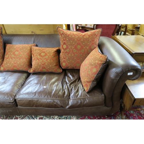 102 - A 20th century brown leather three seater settee red patterned cushions on shaped feet terminating i... 