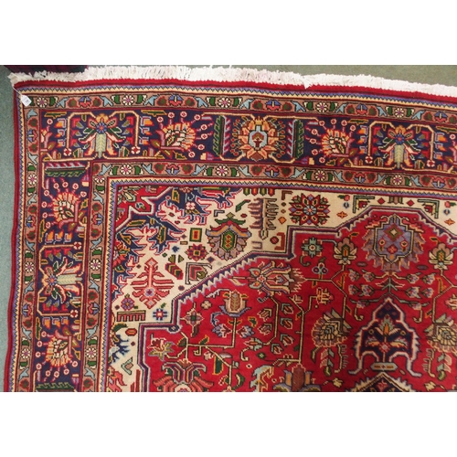 18 - A red ground Kashan rug with dark blue central medallion, white spandrels and a multicoloured flower... 