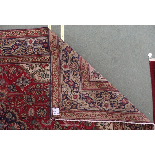 19 - A red ground Tabriz rug with dark blue central medallion, cream spandrels and dark blue borders, 347... 