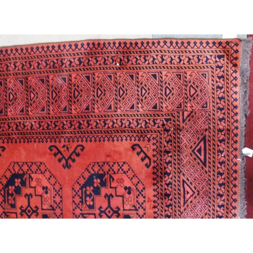 22 - A terracotta ground Bokhara rug with all-over lozenge design and geometric borders, 282cm long x 216... 