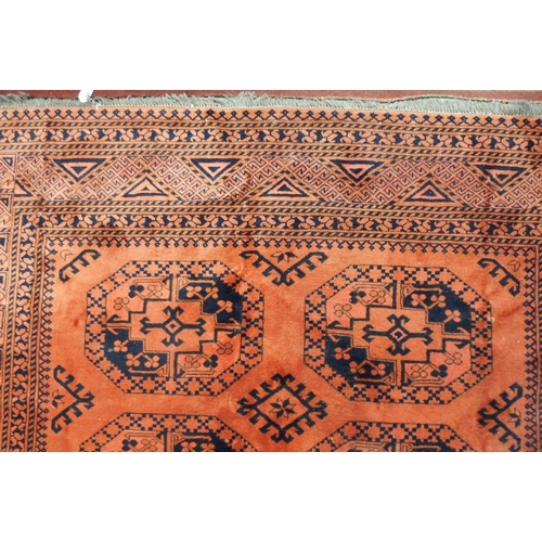 22 - A terracotta ground Bokhara rug with all-over lozenge design and geometric borders, 282cm long x 216... 