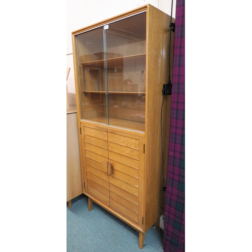 61 - A mid 20th century blonde oak Minty Oxford bookcase with glazed sliding doors over pair of panel doo... 